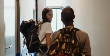 Women Leaving a Hostel with Backpacks