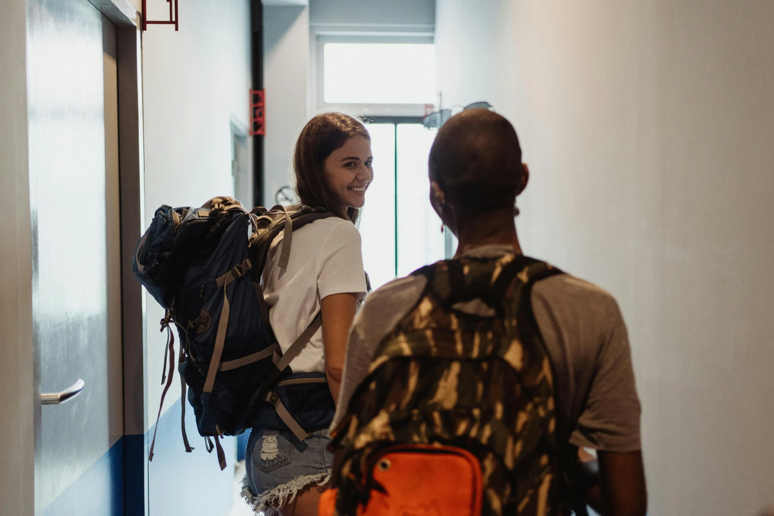 Women Leaving a Hostel with Backpacks