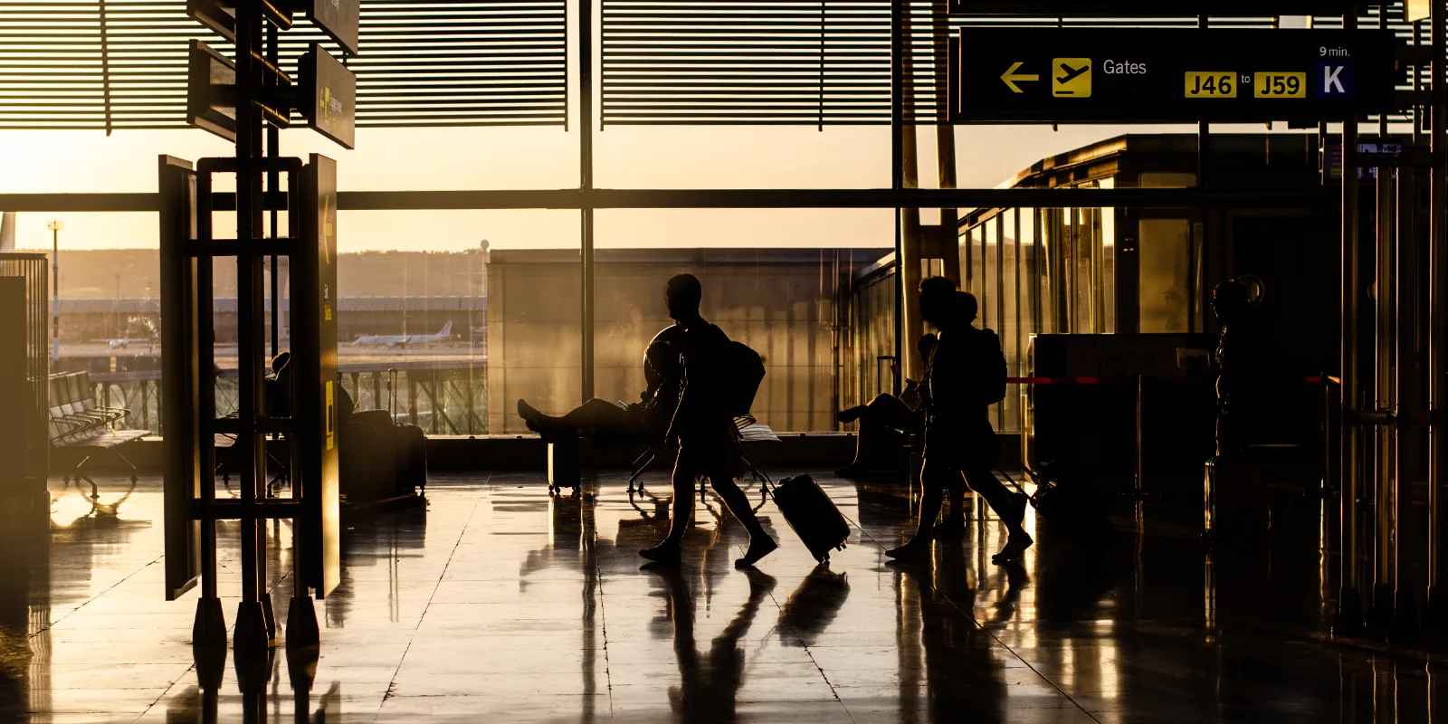 Travellers with luggage walking through an airport terminal