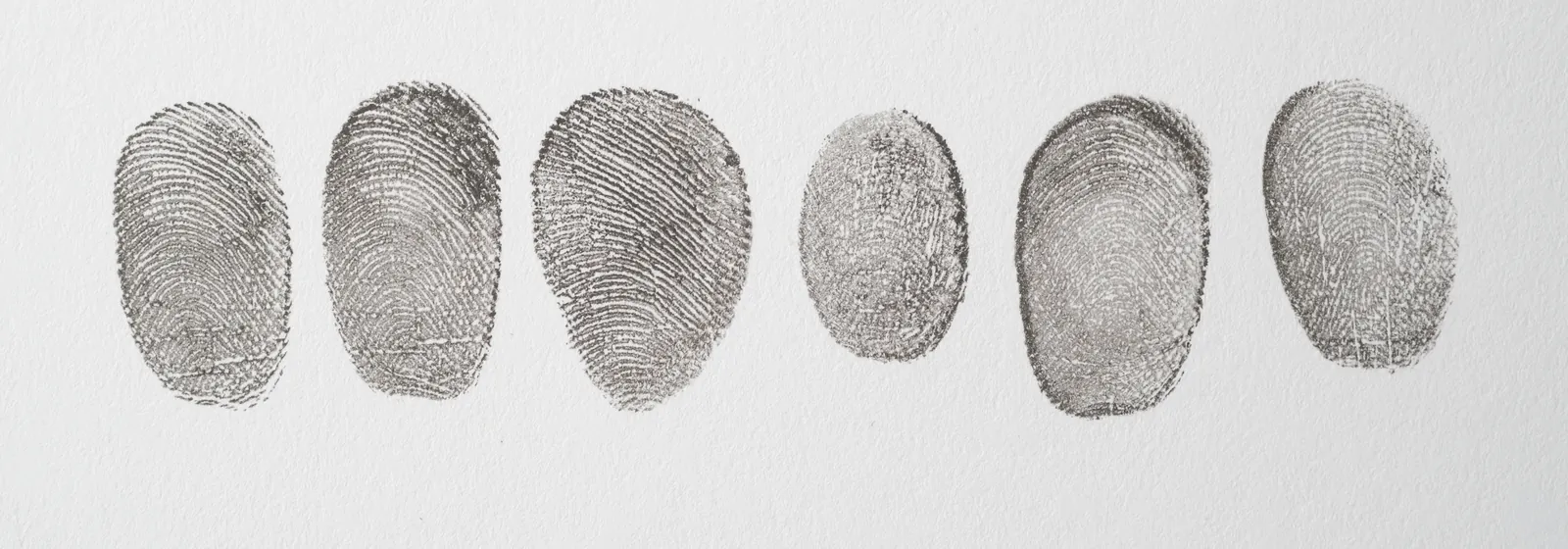 A row of inked fingerprints on white paper