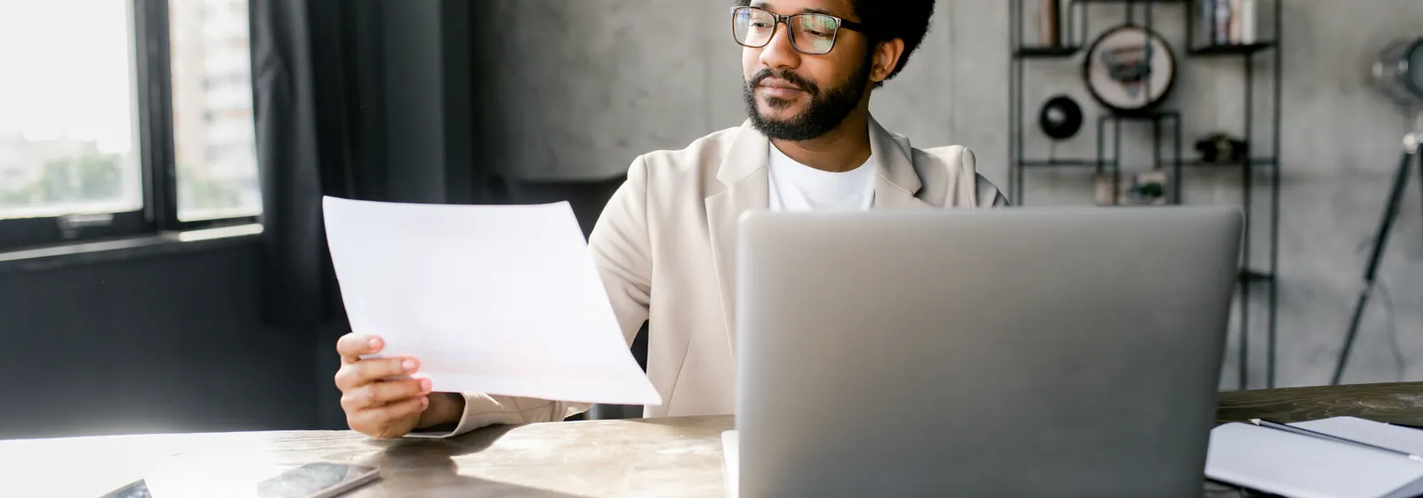 A man reviewing documents at his desk before submitting an application