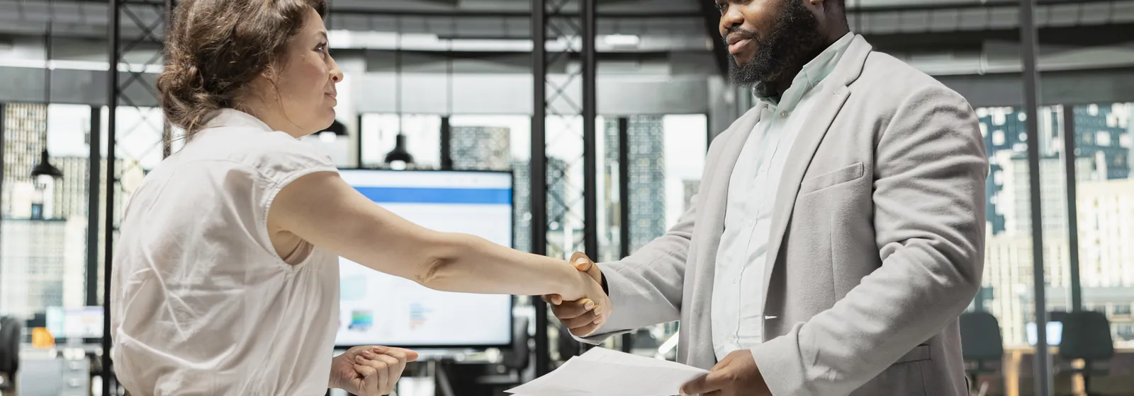 A recruiter and a job candidate shaking hands after an interview